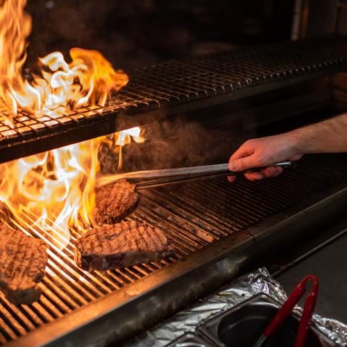 Chef grilling meat at Zelman Meats restaurant in London